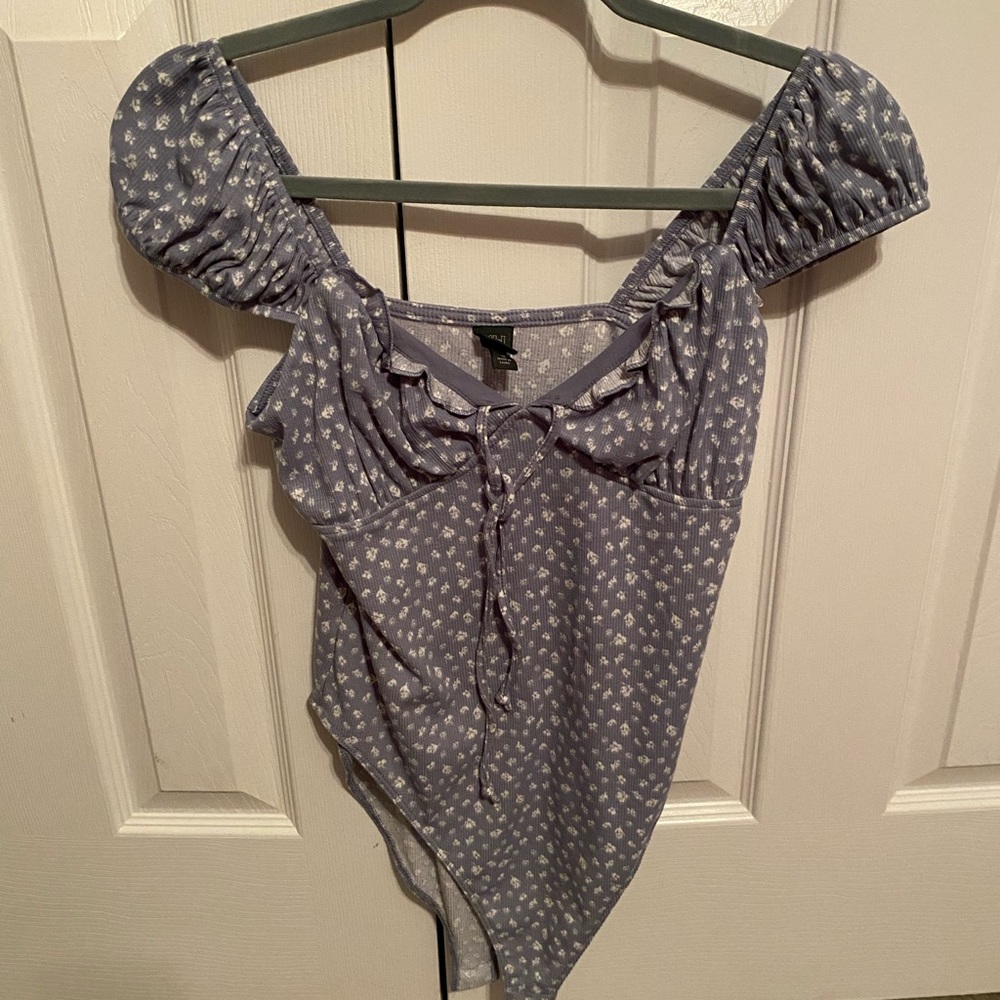 Blue and white floral bodysuit with tie detail and cap sleeves.